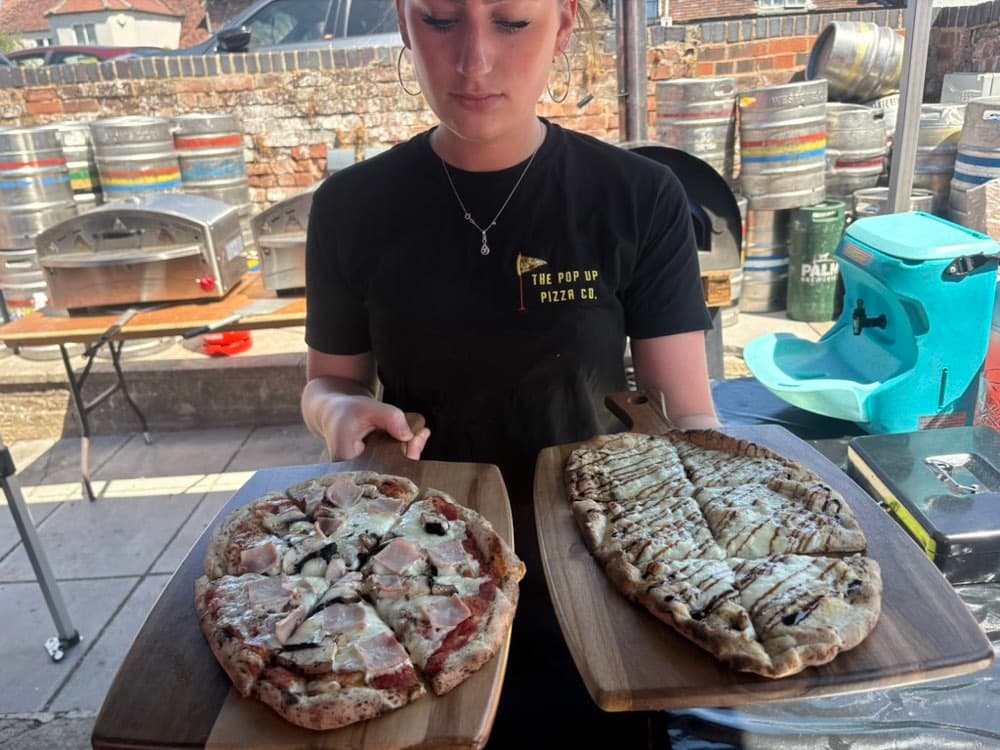 Team member serving freshly made pizzas at a corporate event in Gloucester